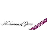 Logo Hillmann und Geitz (Schriftzug in geschwungener, schwarzer Schrift Hillmann & Geitz. Rechts davon eine lila Banderole die von links unten nach rechts oben verläuft mit sehr kleiner, weißer Schrift: Technischer Handel seit 1919)